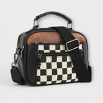 Sac à main noir avec bandoulière, motif damier en poche avant.