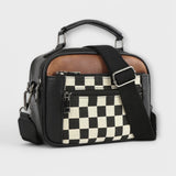 Sac à main noir avec bandoulière, motif damier en poche avant.