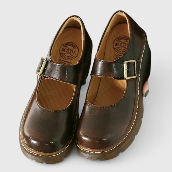 Chaussures bébé en cuir marron foncé, bride à boucle et doublure intérieure marron.