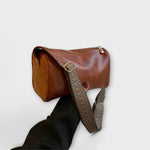 Sac bandoulière vintage en cuir brun, bandoulière tressée à motif et boucle.
