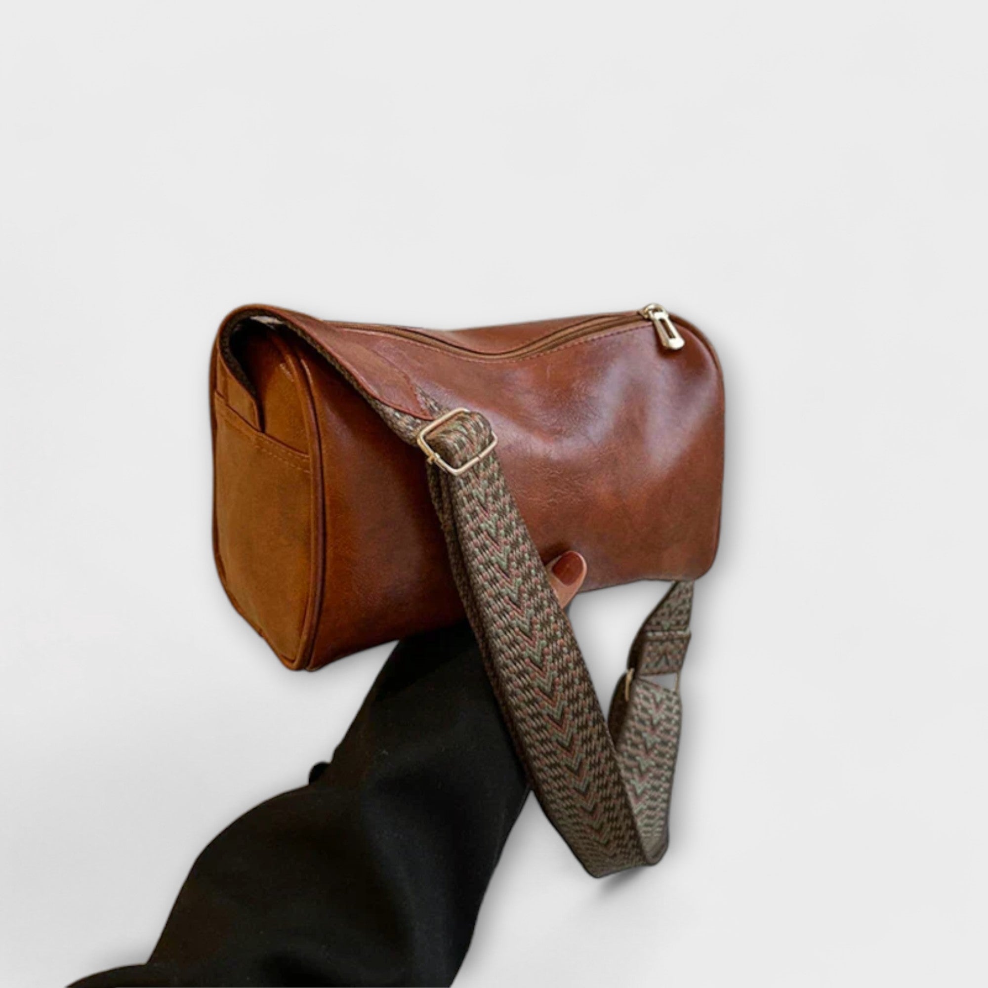 Sac bandoulière vintage en cuir brun, bandoulière tressée à motif et boucle.