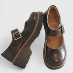 Chaussures bébé en cuir marron, bride à boucle et semelle plateforme avec coutures.