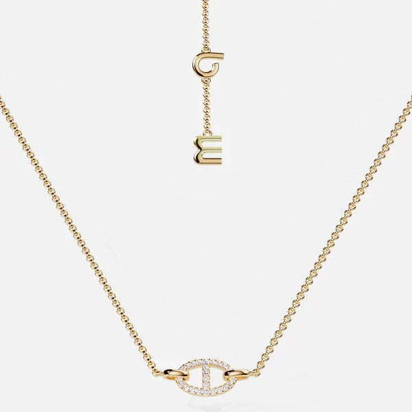 Collier doré avec breloques en lettres stylisées et petit pendentif serti de pierres