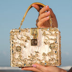 Sac à main rectangulaire blanc, anses dorées, fermoir carré et perles décoratives