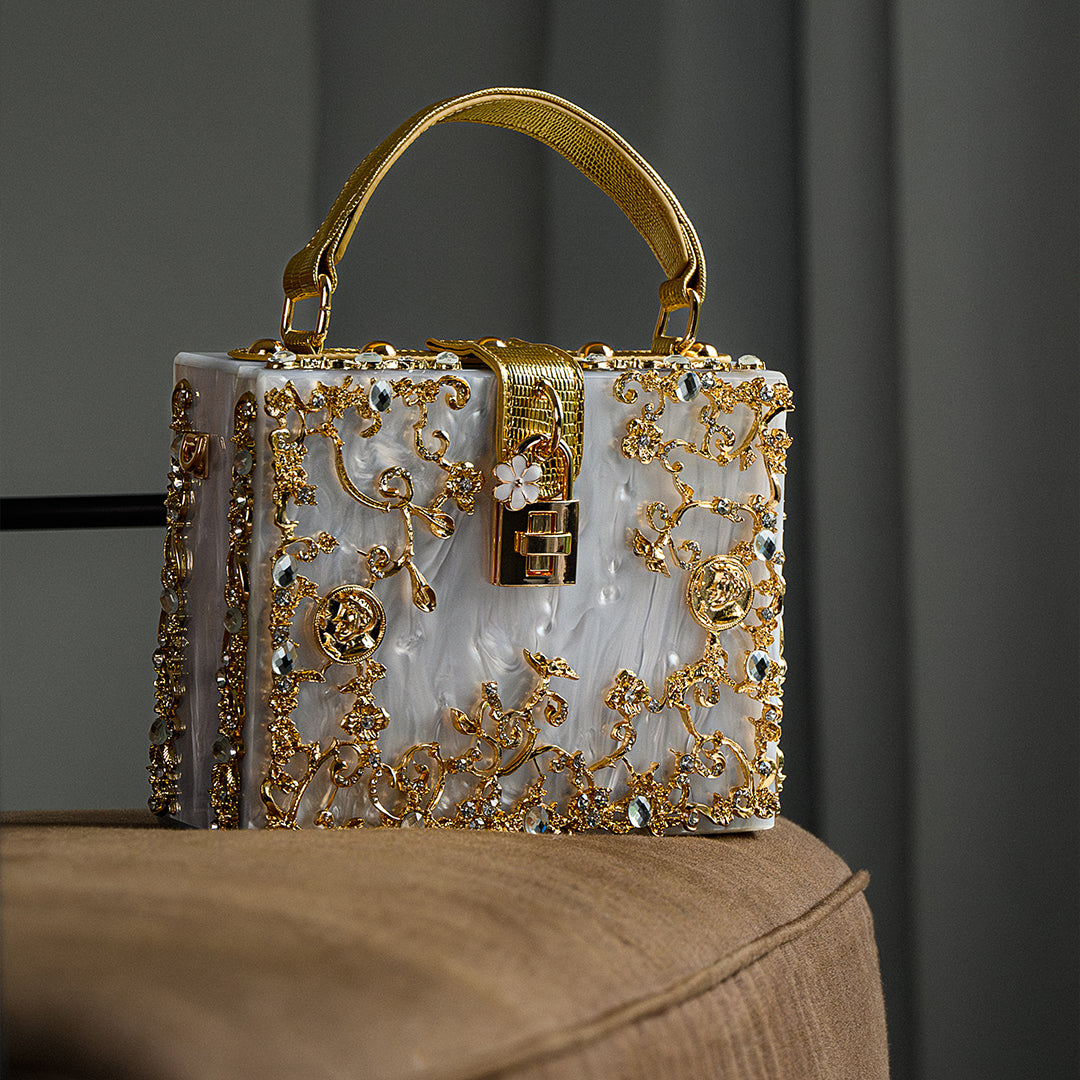 Sac à main rectangulaire blanc, décor doré en relief, anse et chaînettes latérales