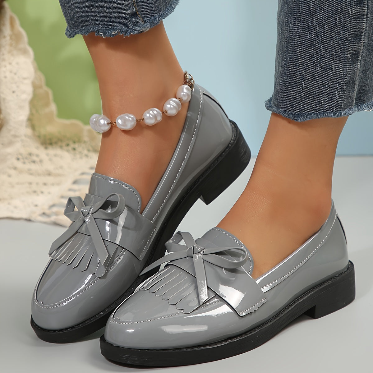 Mocassins gris à pampilles avec nœud décoratif et bout brillant, semelle noire
