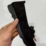 Mocassins noirs en daim, vue de côté, semelle crantée et nœud sur l’empeigne