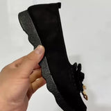 Mocassins noirs en daim, vue de côté, semelle crantée et nœud sur l’empeigne