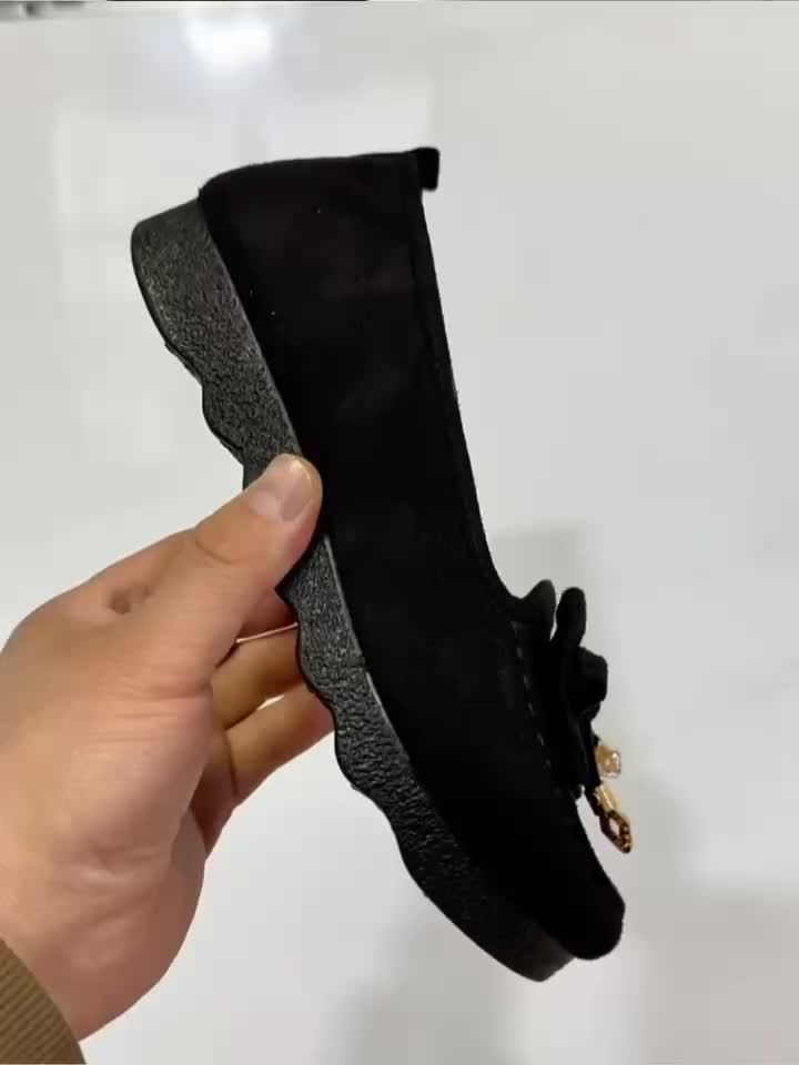 Mocassins noirs en daim, vue de côté, semelle crantée et nœud sur l’empeigne