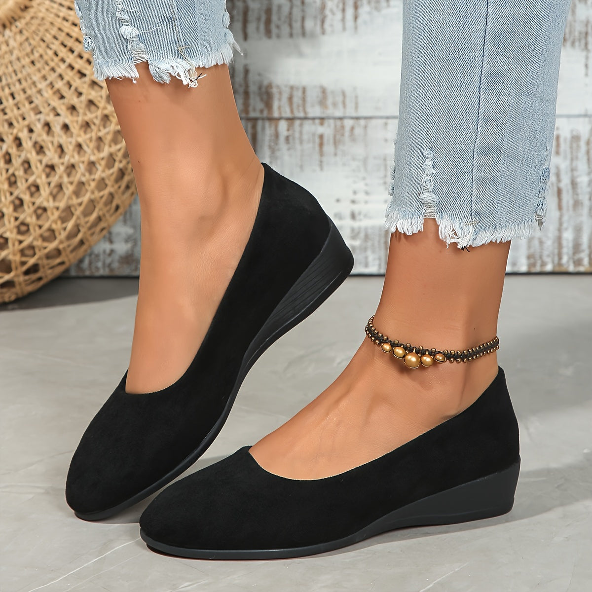 Ballerines compensées en daim noir, vue rapprochée du bout et du talon.
