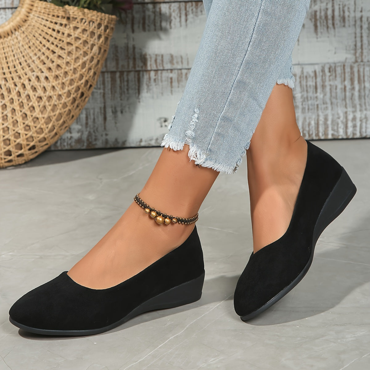 Ballerines compensées en daim noir, vue latérale avec talon compensé.