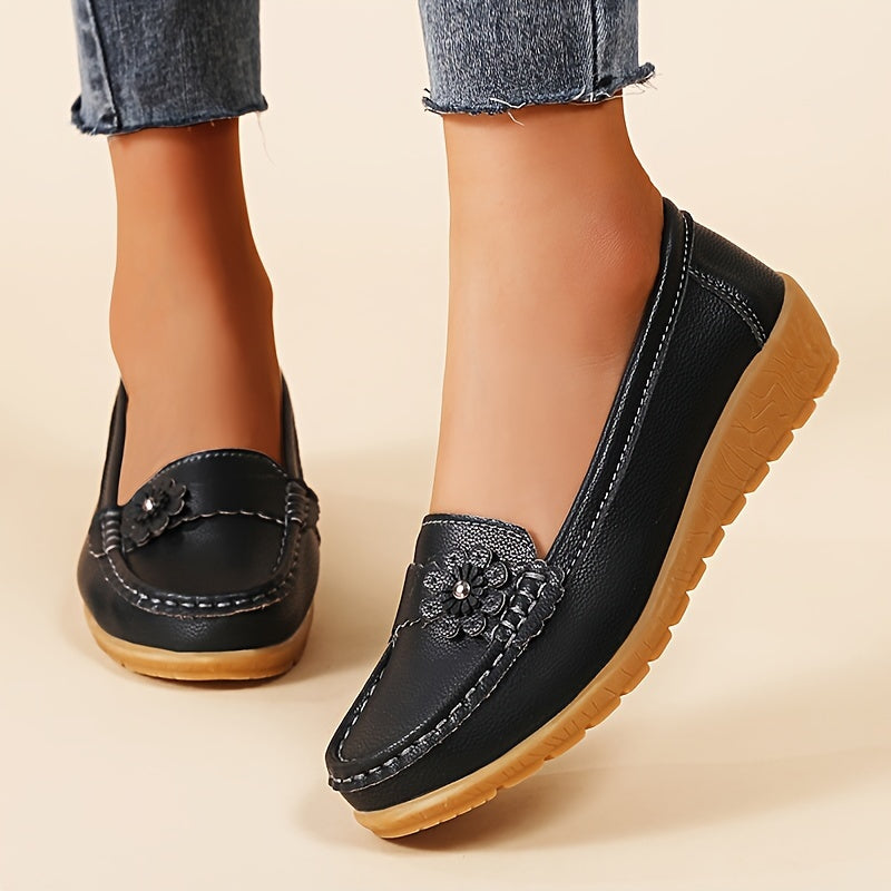 Mocassins Zélie noirs en cuir souple, ornement floral, semelle crantée.
