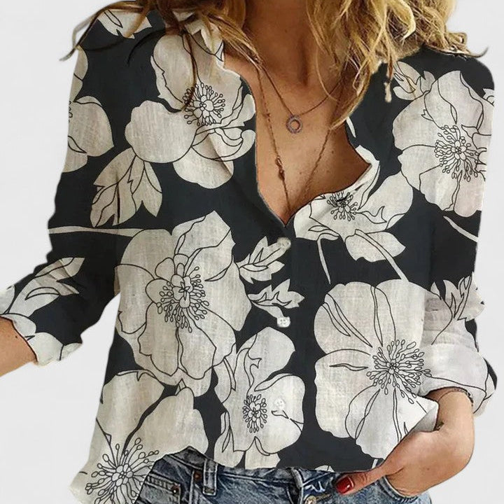 Blouse boutonnée col en V à manches 3/4, noir et blanc, motifs floraux contrastés.