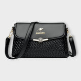 Sac à bandoulière noir en cuir tressé, rabat avec fermoir fleur, logo BALDASHU