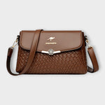 Sac à bandoulière marron en cuir tressé, rabat avec fermoir fleur, logo BALDASHU