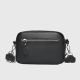 Sac à bandoulière en cuir noir, fermeture zippée visible, bandoulière et attaches métalliques.