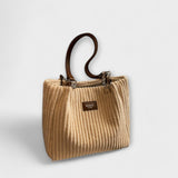 Sac à bandoulière en cordon doux beige clair, petit label central et sangles.