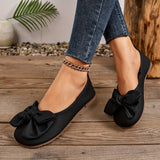 Ballerines à bout arrondi noires à nœud, portées avec jeans