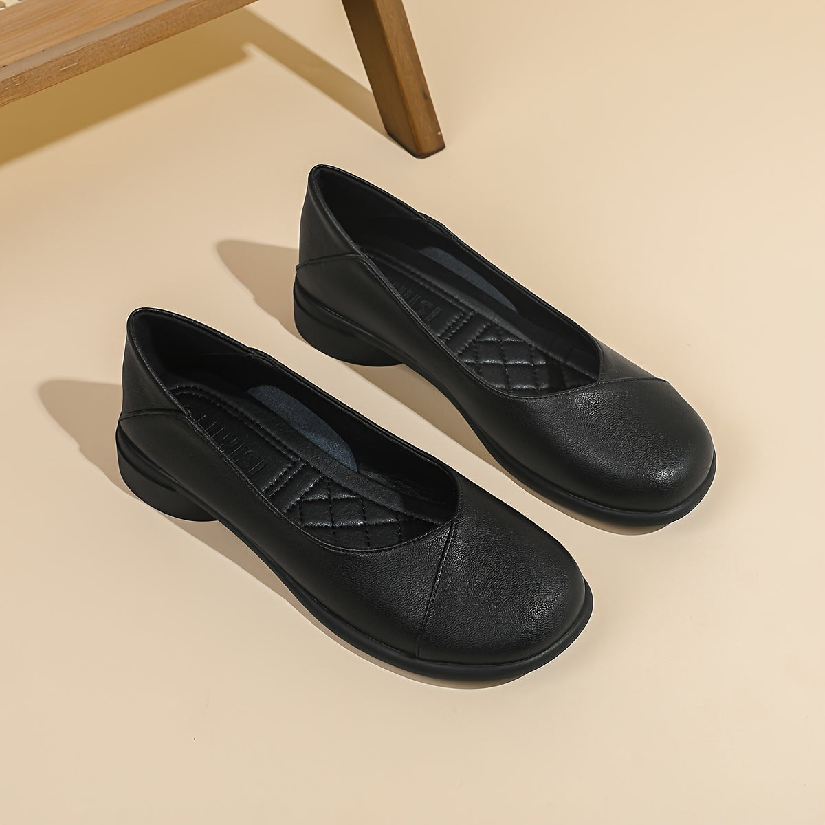 Paire de ballerines noires souples, bout arrondi, couture décorative, vue latérale