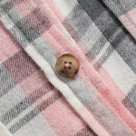 Chemise à carreaux rose et gris, gros plan sur bouton et couture du col.
