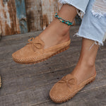 Sabots mocassin en daim camel avec nœud, motif perforé et semelle épaisse à picots.