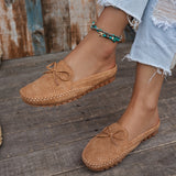 Sabots mocassin en daim camel avec nœud, motif perforé et semelle épaisse à picots.