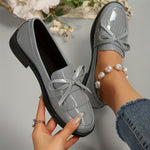 Mocassins gris vernis à pampilles, nœud frontal et détail de couture