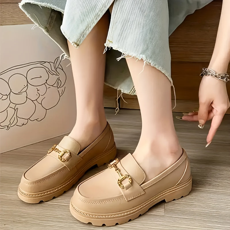 Mocassins beige à boucle dorée, portés, semelles épaisses et patte avant décorée