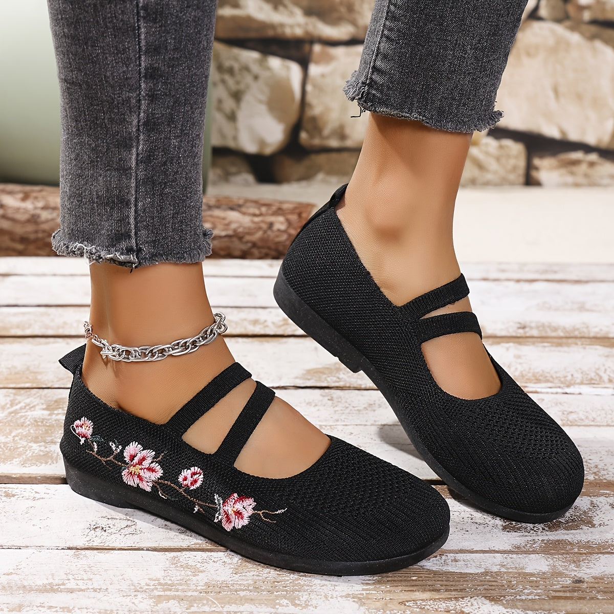 Chaussures plates noires à brides ajourées, motif floral brodé sur le dessus.