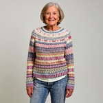Pull en laine à col rond, motif jacquard multicolore sur fond bleu foncé.