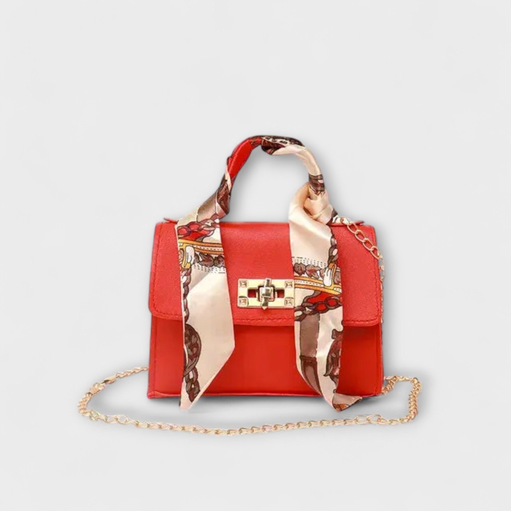 Sac à main rouge avec foulard imprimé, rabat, fermoir rectangulaire, chaîne dorée.